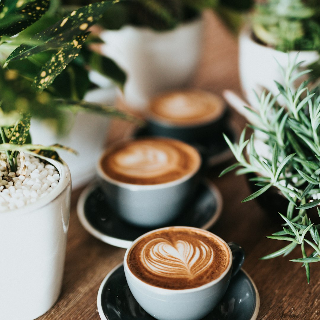 Three cortados with latte art on a wooden table at a Pasadena coffee shop